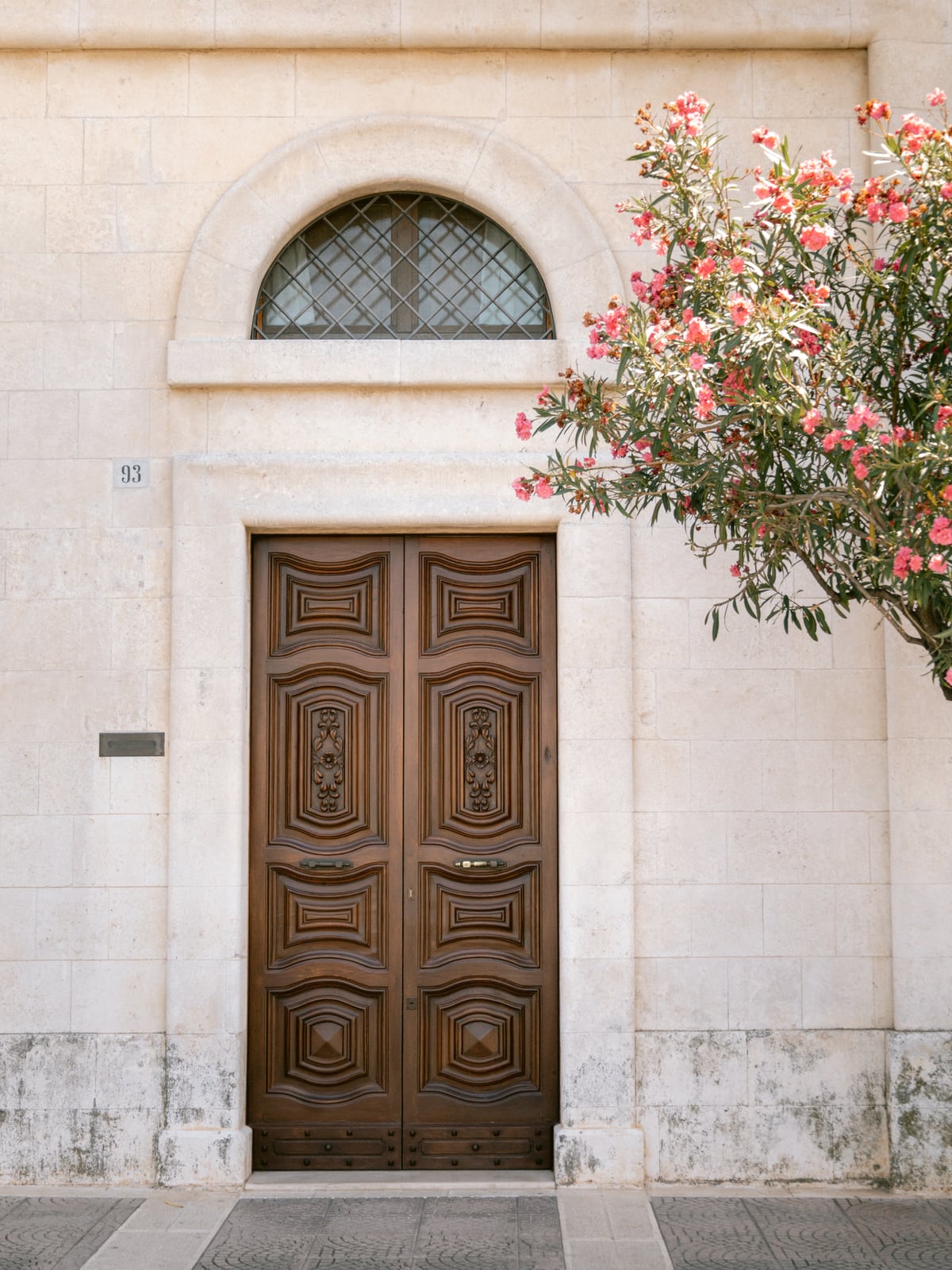 Mediterranean brown wooden door and pink flowers by Marika Huisman