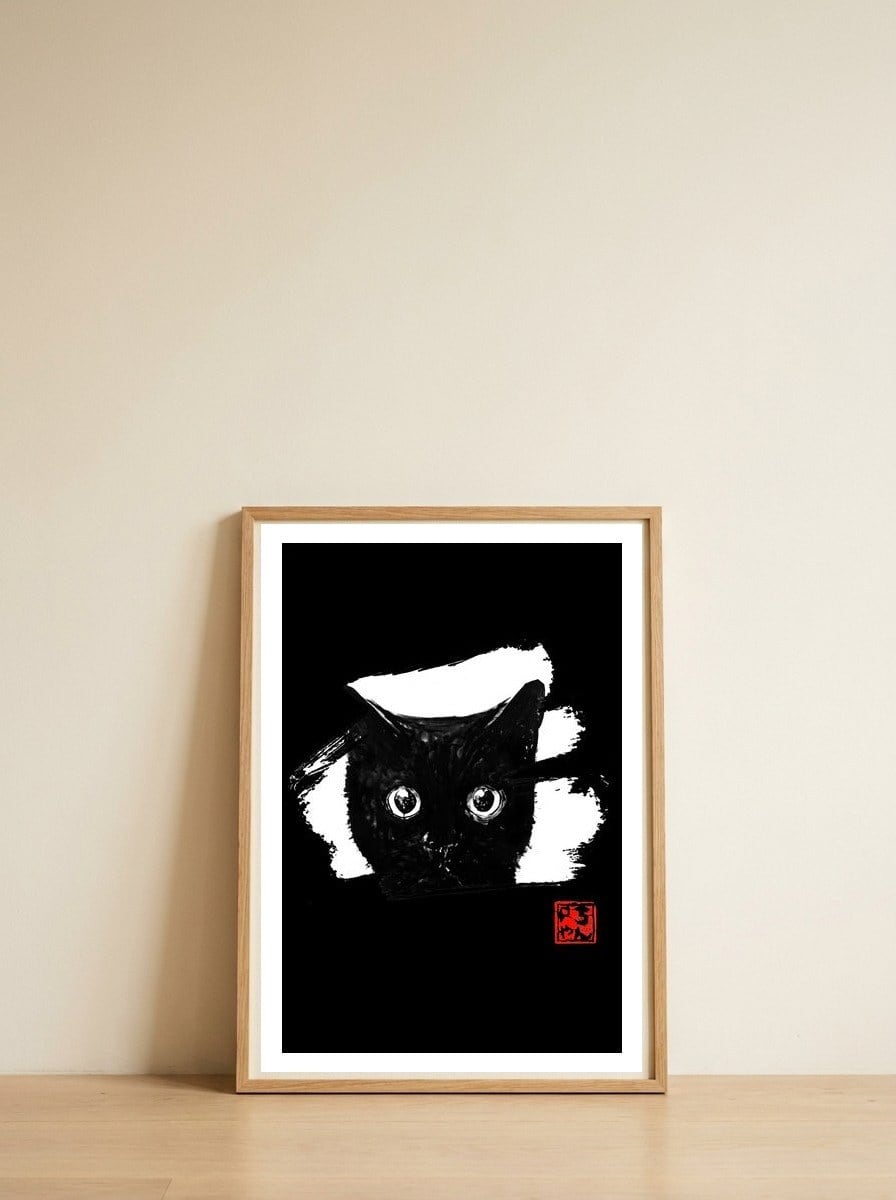 cat face in white — framed, leaning against the wall