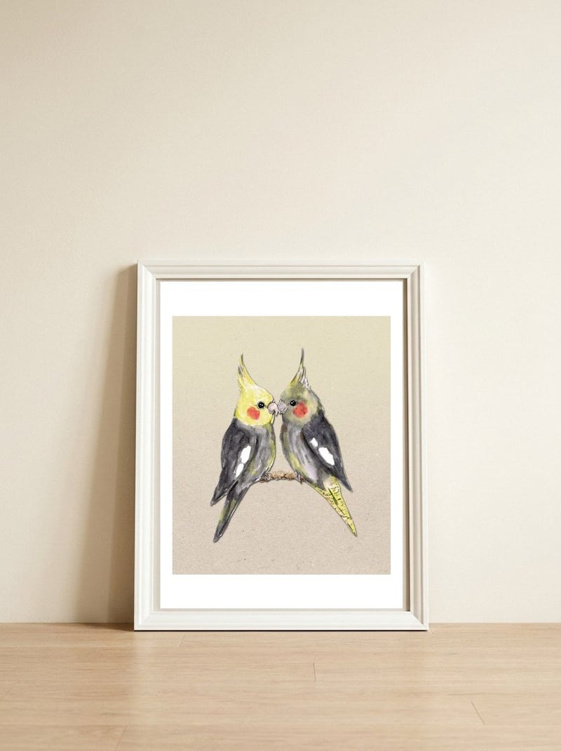 Two cute cockatiels — framed, leaning against the wall