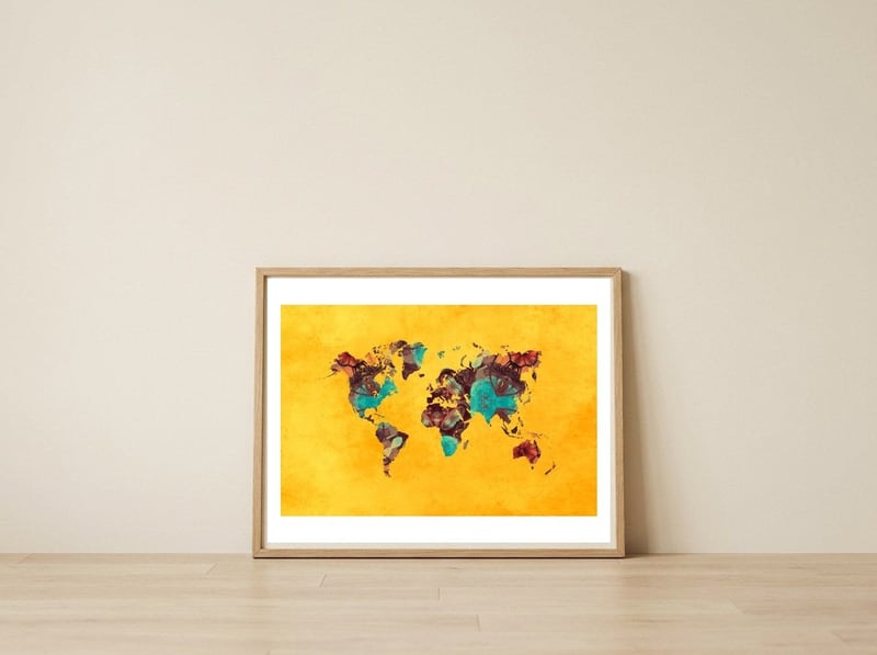 world map yellow art — framed, leaning against the wall
