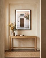 Mediterranean brown wooden door and pink flowers framed in a welcoming room thumbnail