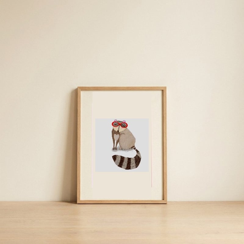 Raccoon Red Sunglasses — framed, leaning against the wall