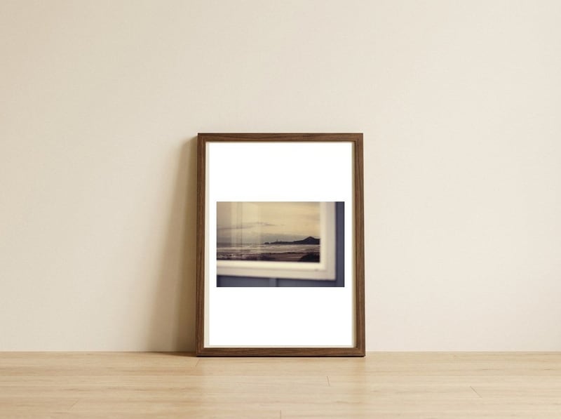 Lighthouse reflection — framed, leaning against the wall
